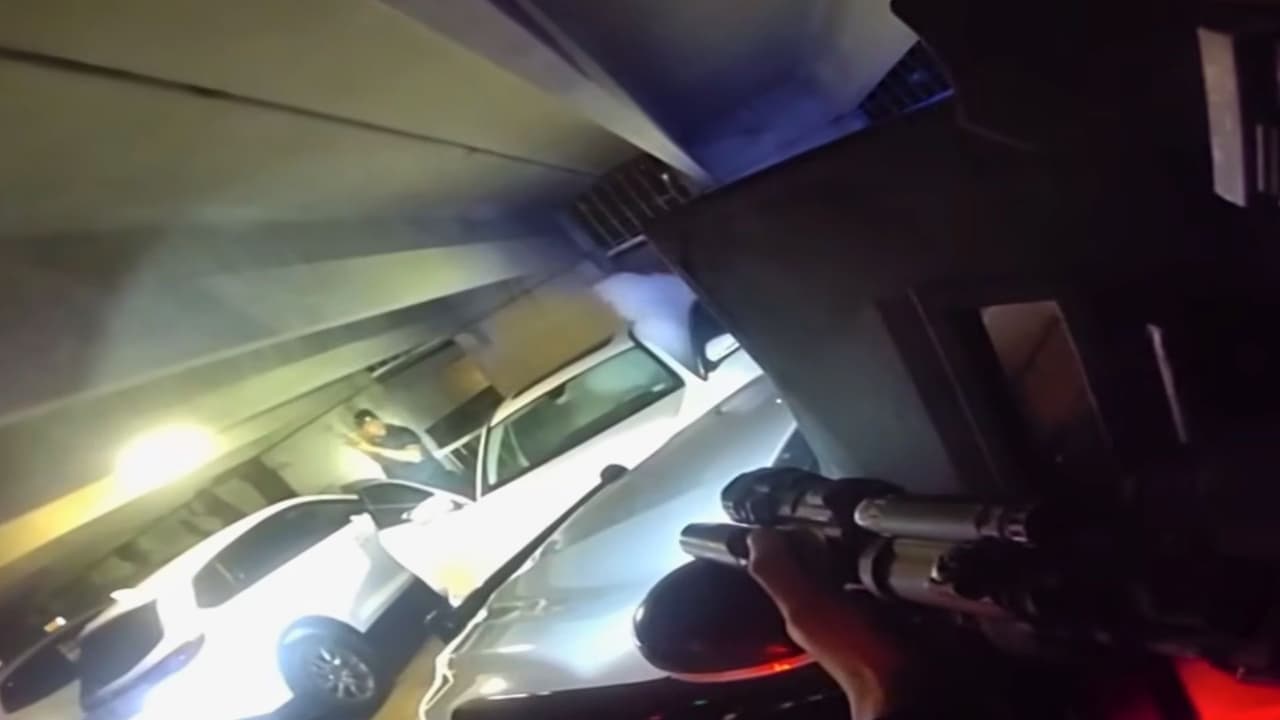 Diamon Maziarre Robinson baja de un Mercedes Benz mientras oficiales de policía lo apuntan.