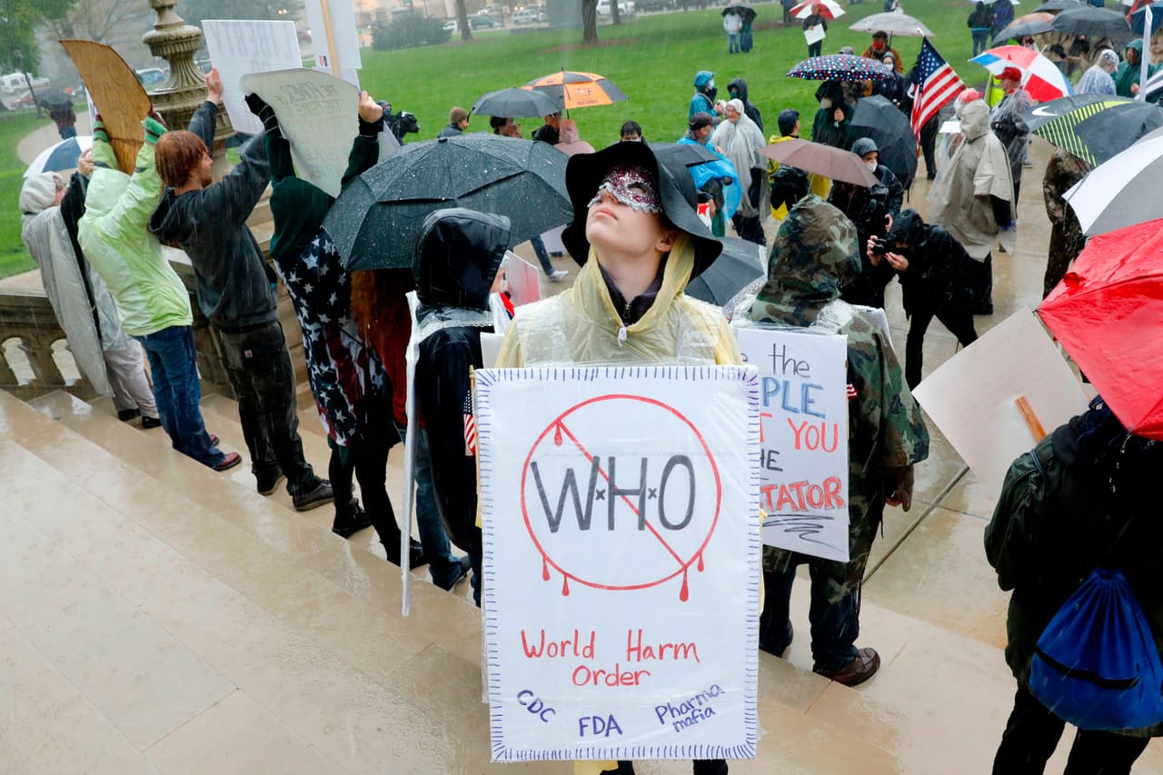 "Quién daña el orden mundial... FDA, los CDC...". Protesta en Lansing, Michigan, 28 de mato del 2020.