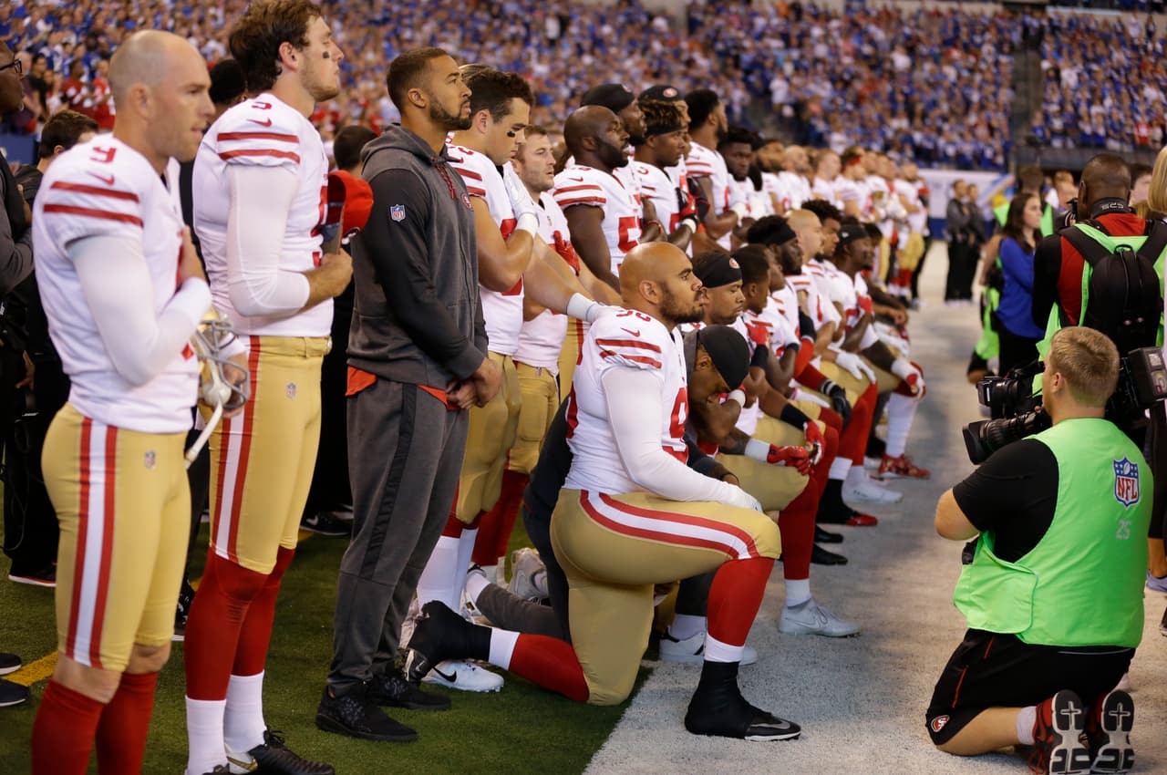 Member of the San Francisco 49ers kneel during the playing of the national anthem before an NFL football game against the Indianapolis Colts, Sunday, Oct. 8, 2017, in Indianapolis. (AP Photo/Michael Conroy)