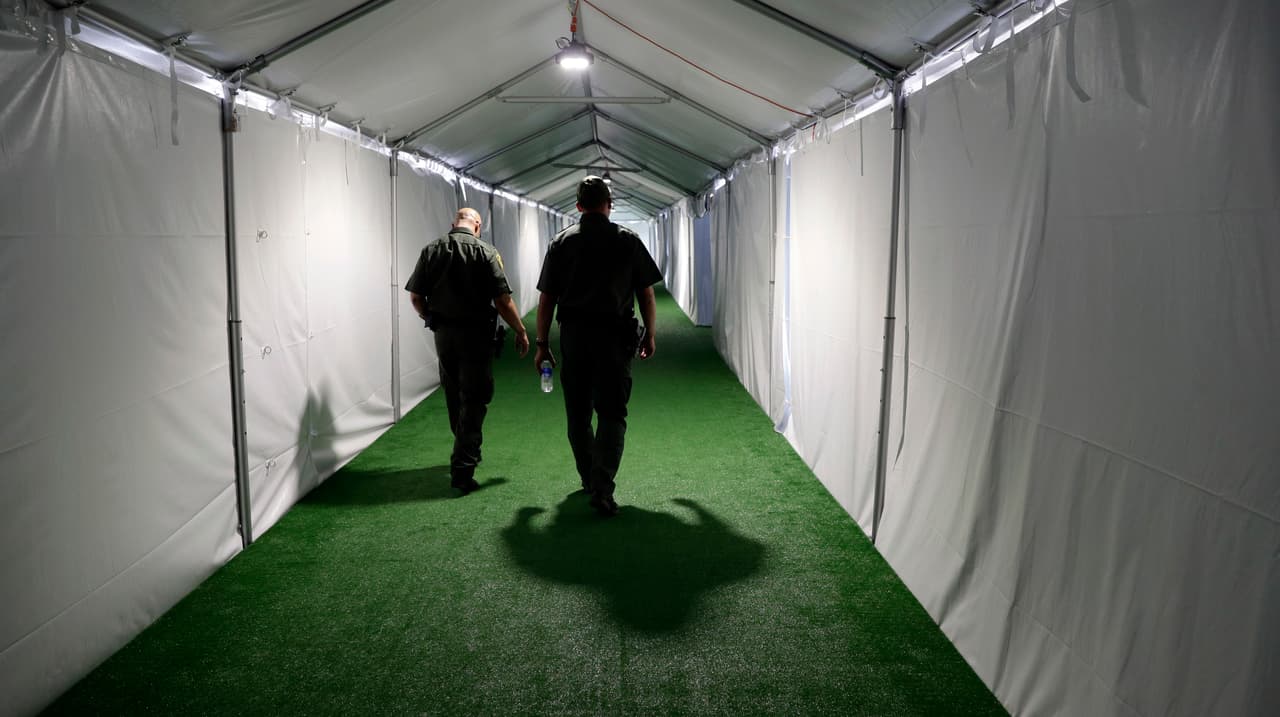 Agentes de la ´patrulla fornteriza caminan por un pasillo de un centro de detención en Donna, Texas
