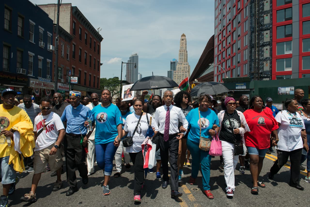 Encadenados en un sentir, Al Sharpton (con corbata) lidera la marcha junto a la familia inmediata de Eric Garner.