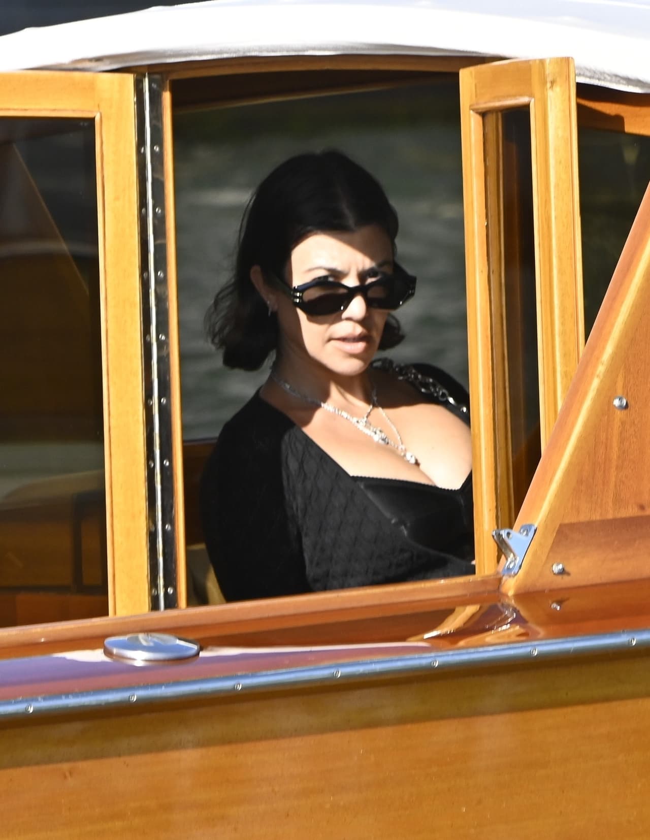 Un bolso con cadenas metálicas que apenas llegaba a la cintura, lentes negros y un collar con calaveras y cruces en capas fueron los accesorios que complementaron su 'outfit' para recorrer los canales de Venecia.