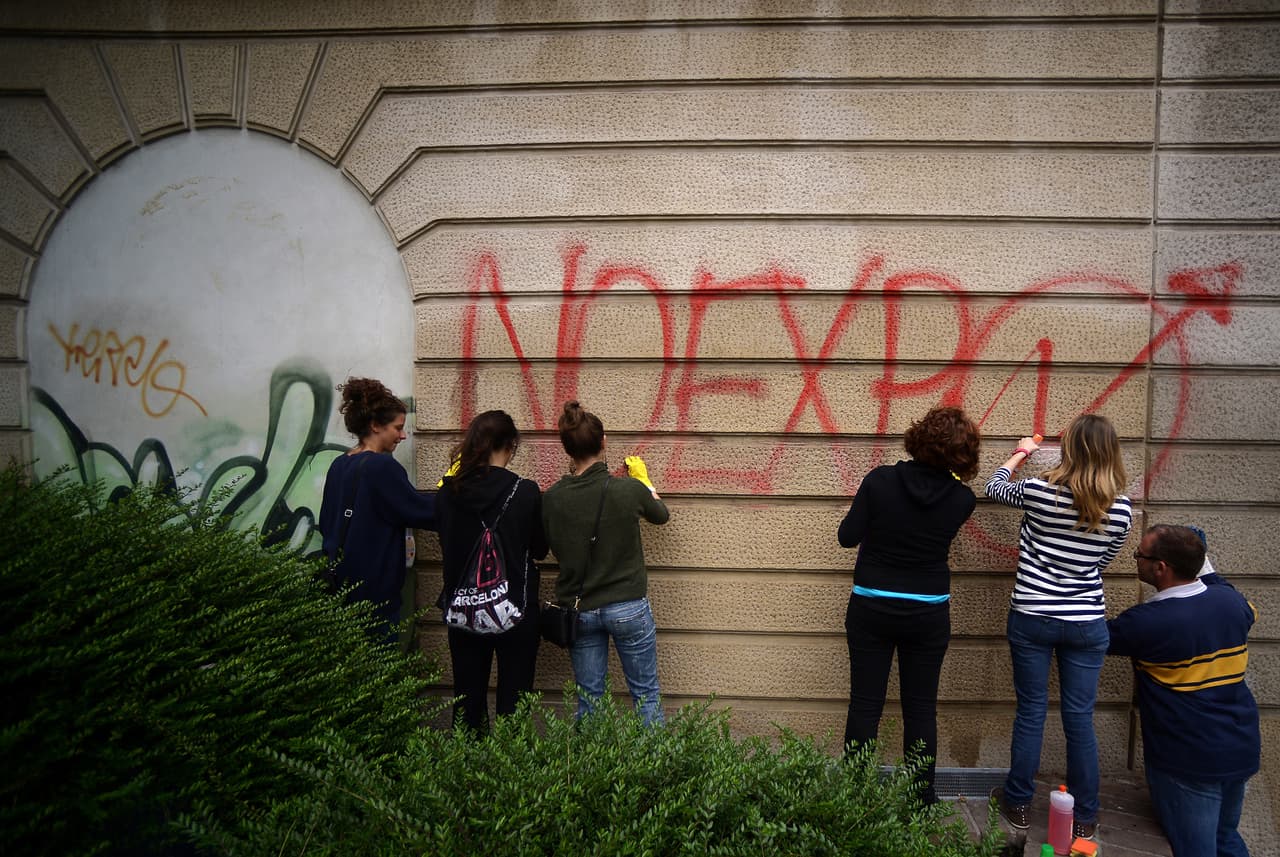 Milaneses limpian graffitis de protesta en contra de la Exposición en esa ciudad, celebrada en 2015.