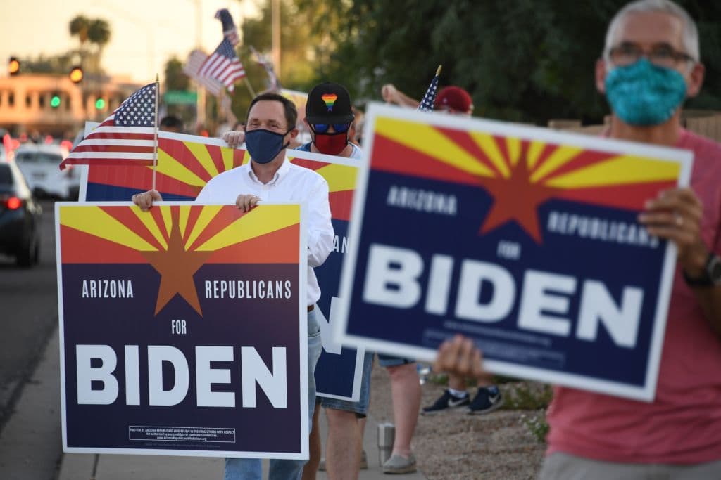 Members of the group "Arizona Republicans Who Believe In Treating Others With Respect" hold signs in support of Democratic presidential candidate Joe Biden, during evening rush hour in Phoenix, Arizona on October 16, 2020.