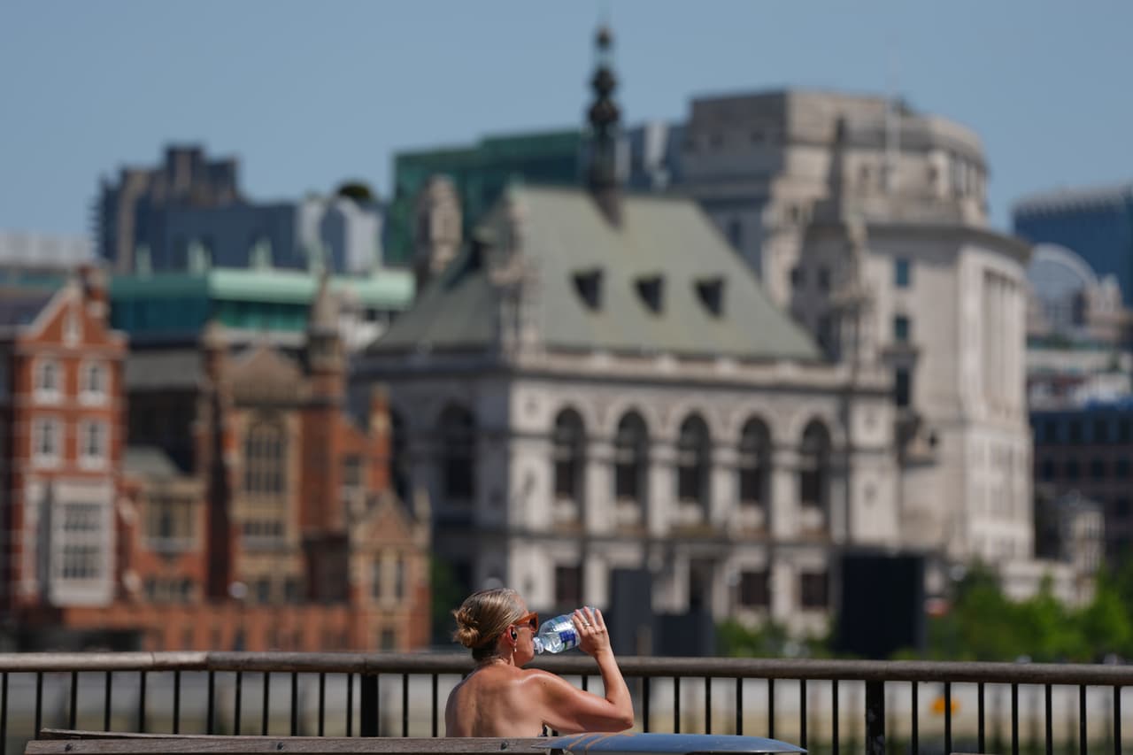 Una mujer en Londres bebe agua ante las altas temperaturas que asolan el continente europeo.