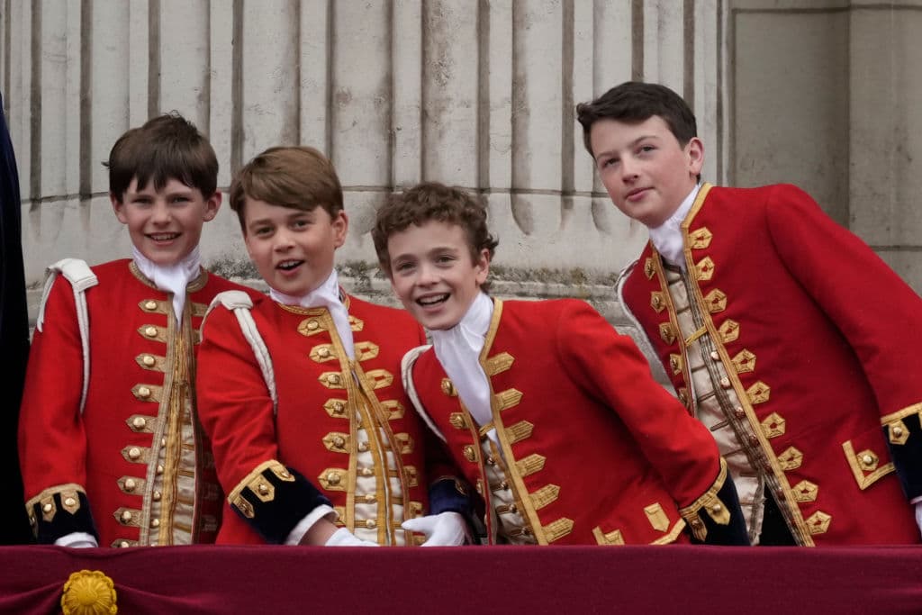 Sin dudas, los niños de la realeza jugaron un gran papel en la 
<a href="https://www.univision.com/noticias/mundo/coronacion-rey-carlos-iii-en-vivo">ceremonia de coronación de Carlos III</a> y la reina Camila este sábado. 
<br>
<br>En la foto, de izquierda a derecha: el page de honor, 
<b>Lord Oliver Cholmondeley, George, príncipe de Gales, el page de honor Nicholas Barclay y el page de honor Ralph Tollemache</b>, saludan desde el balcón del Palacio de Buckingham, al cierre de la ceremonia.