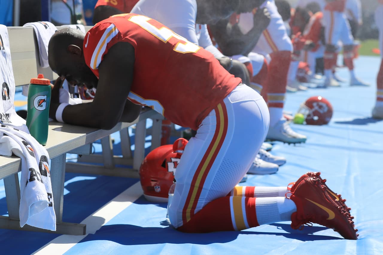 Justin Houstin, de los Kansas City Chiefs, se arrodilló en la banca mientras las notas del himno sonbaban en el StubHub Center ante Los Angeles Chargers.
