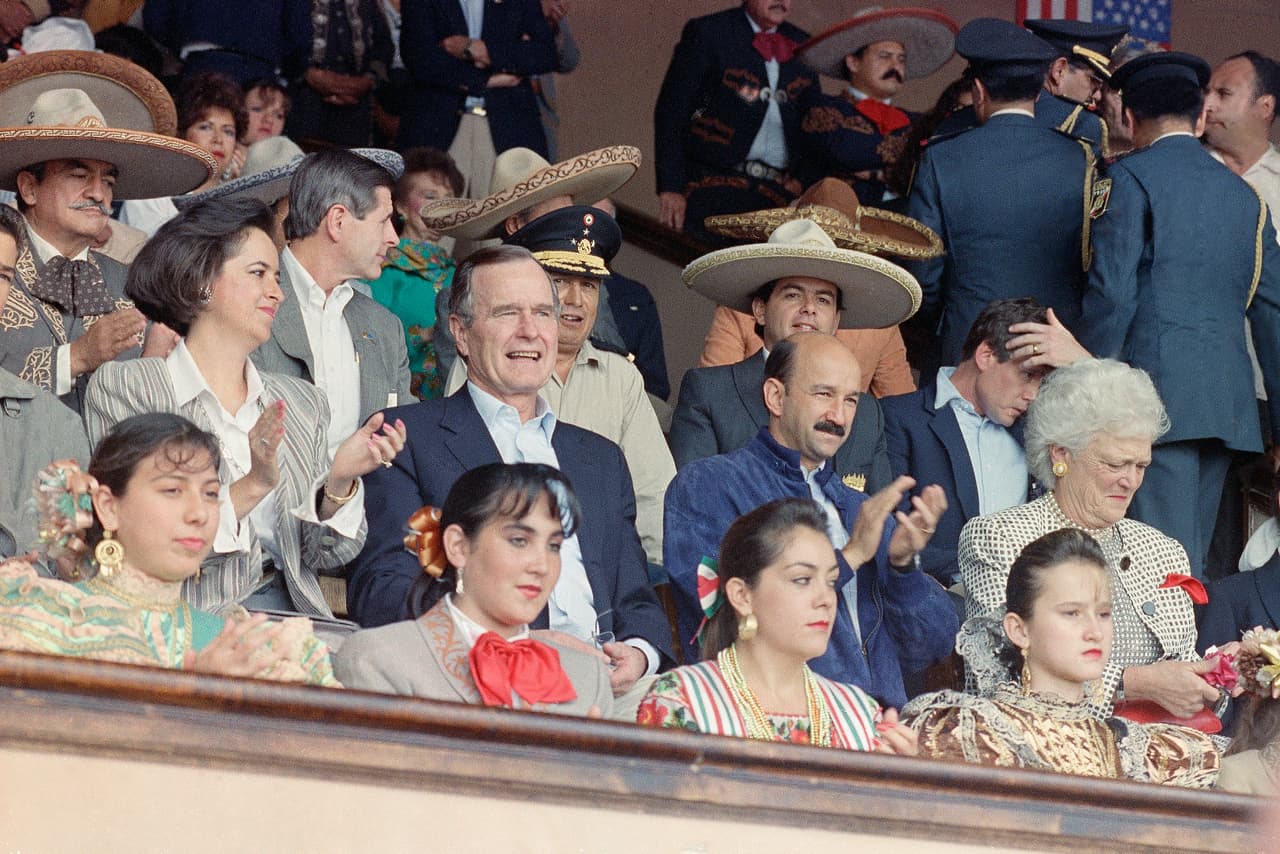 Cecilia Occelli (a la izquierda de George Bush) compartió, según el podcast, que la gente le ha mostrado su cariño a pesar de las acusaciones políticas a su exmarido: "Eso se maneja fuera, tuve la gran suerte que 
<b>la gente es muy amable conmigo,</b> a través de todo lo que ha pasado y antes del sexenio y tiempo después".
<br>