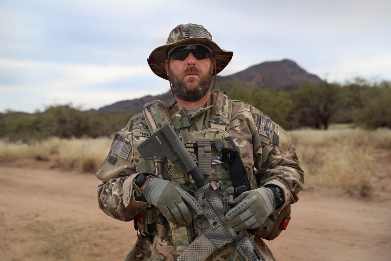 Los voluntarios patrullan el área con uniformes camuflados, rifles y pistolas.
