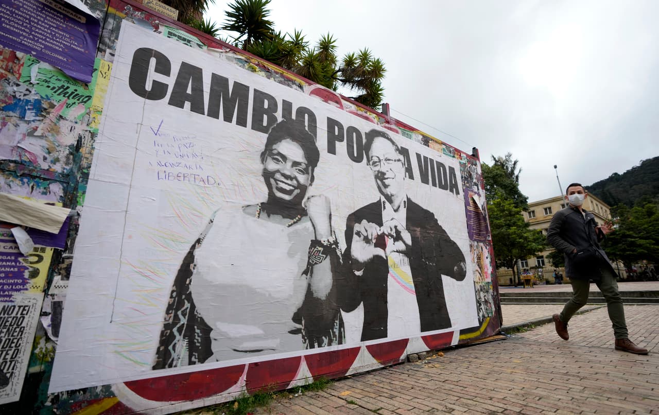 Un hombre pasa frente a un cartel de campaña del candidato presidencial Gustavo Petro y su compañera de fórmula Francia Márquez, con la coalición Pacto Histórico, en Bogotá, Colombia, el miércoles 25 de mayo de 2022.