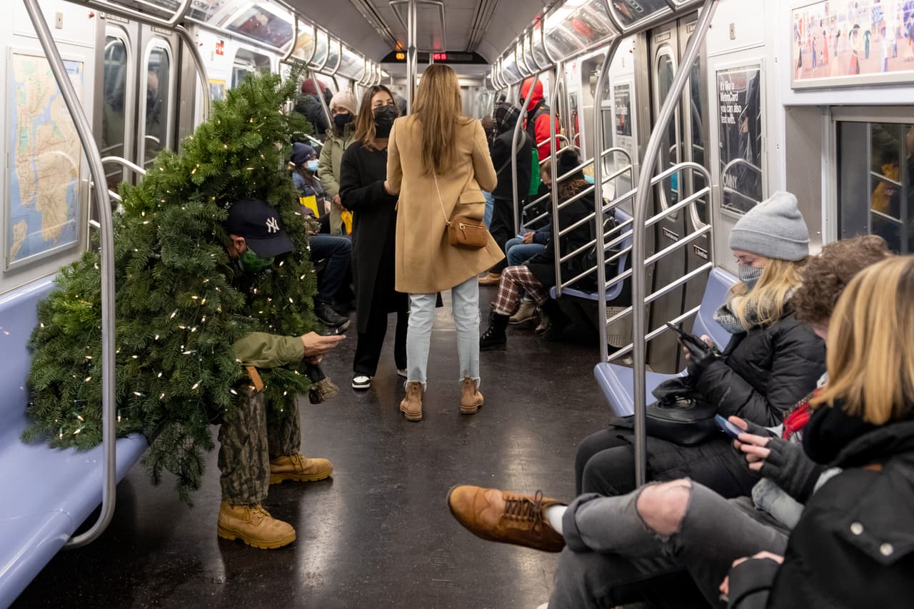 El hombre detrás del famoso disfraz se llama Tommy Liberto, quien vive en Bel Air, Maryland, pero visita Nueva York cada año por estas fechas para traer a los neoyorquinos al "Señor Árbol de Navidad". Aquí lo vemos sentado en el subway. 
<br>
<br>