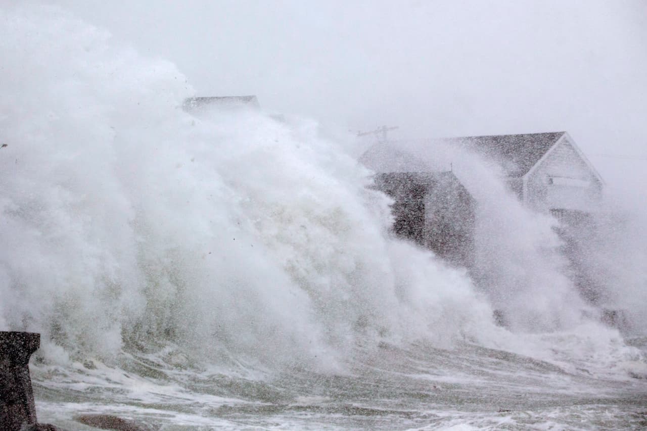 Las olas golpean las casas de la costa en Scituate, Massachusetts