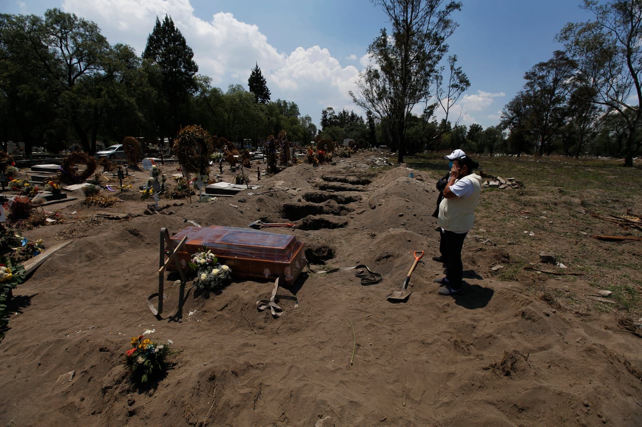 Familiares despiden a una víctima de la pandemia en el cementerio San Lorenzo Tezonco. Los mismos trabajadores deben cargan los ataúdes y sólo se permite que dos familiares acompañan al féretro a la tumba. Los entierros duran apenas unos 15 minutos.
<br>