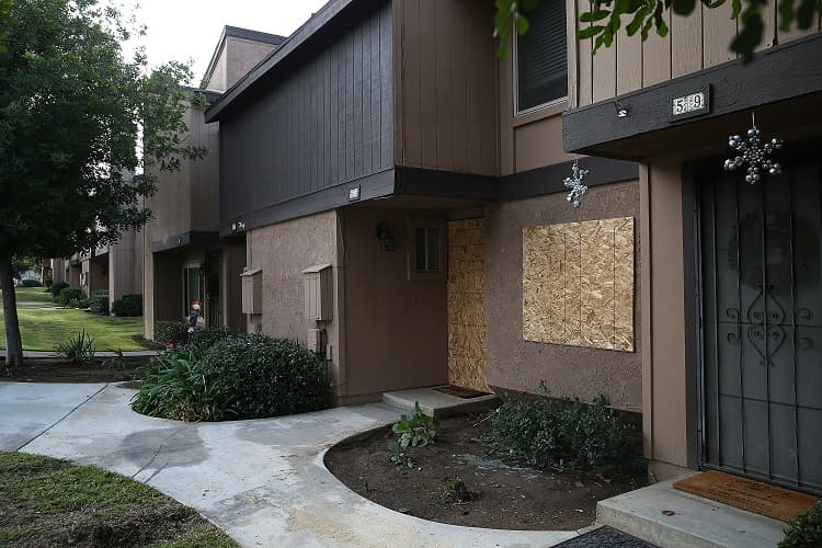 Maderas en las ventanas después de que la policía y el FBI trabajaran en la casa.