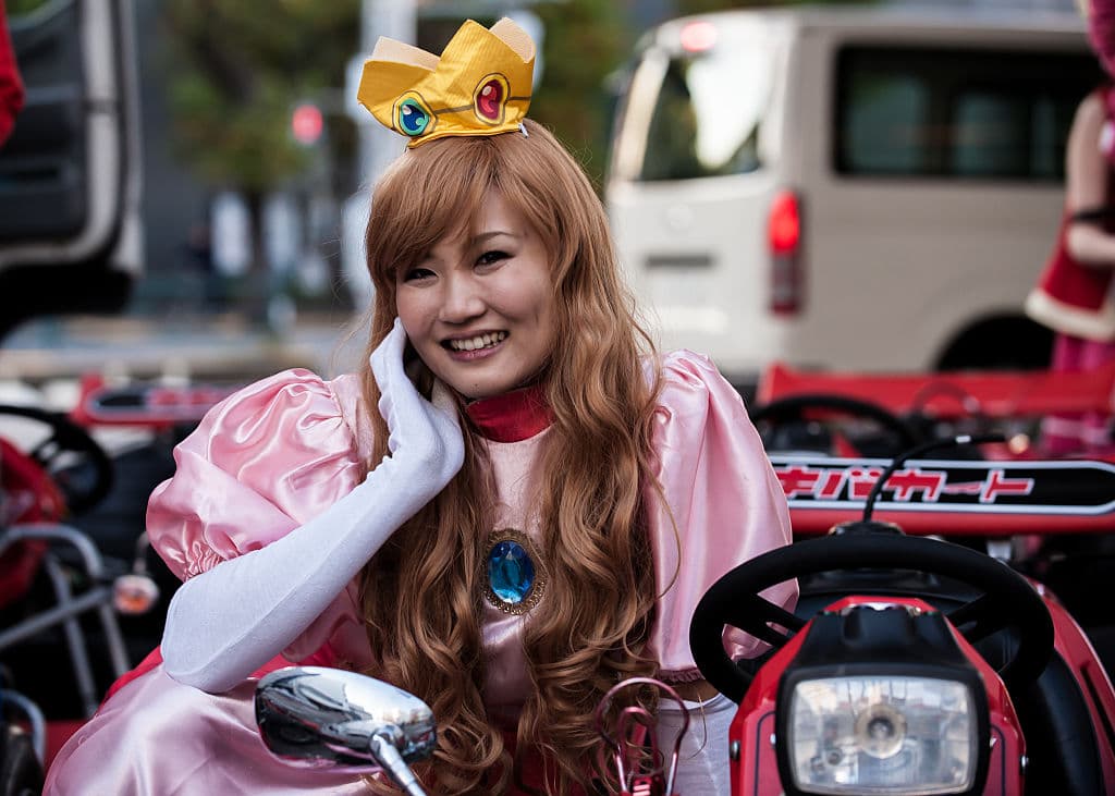 TOKYO, JAPAN - NOVEMBER 16: Participant in Princess Peach costume poses for photo for the Real Mario Kart event in Tokyo on November 16, 2014 in Tokyo, Japan. The organizer calls for participants to this event held about once a month on Facebook, and Akiba Kart offers rental karts that can be driven on public streets. (Photo by Keith Tsuji/Getty Images)