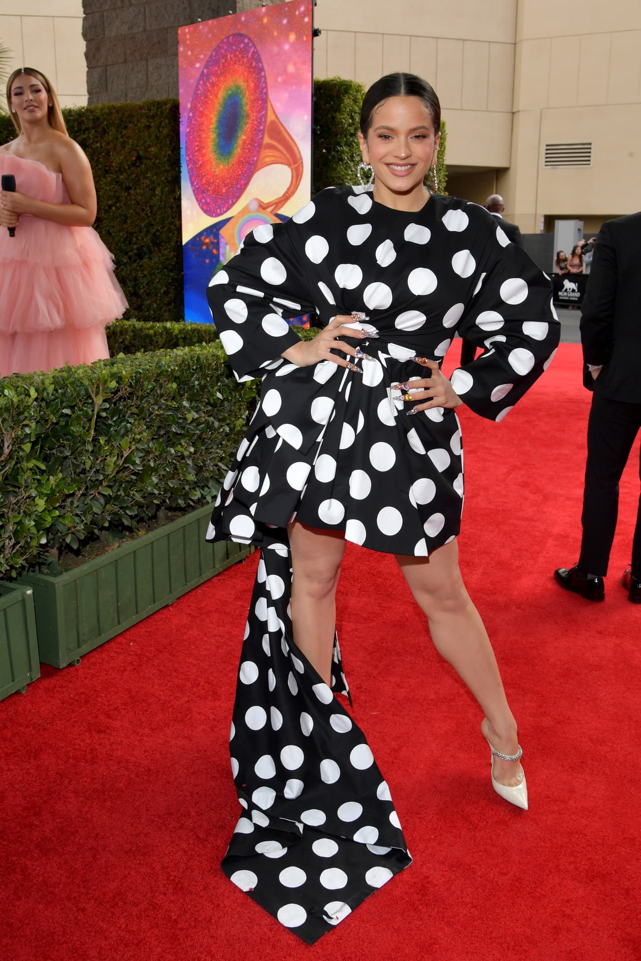 Como para resaltar sus orígenes, la española Rosalía eligió un vestido con falda de vuelos de lunares blancos sobre negro. Acompañó con zapatos Jimmy Choo.