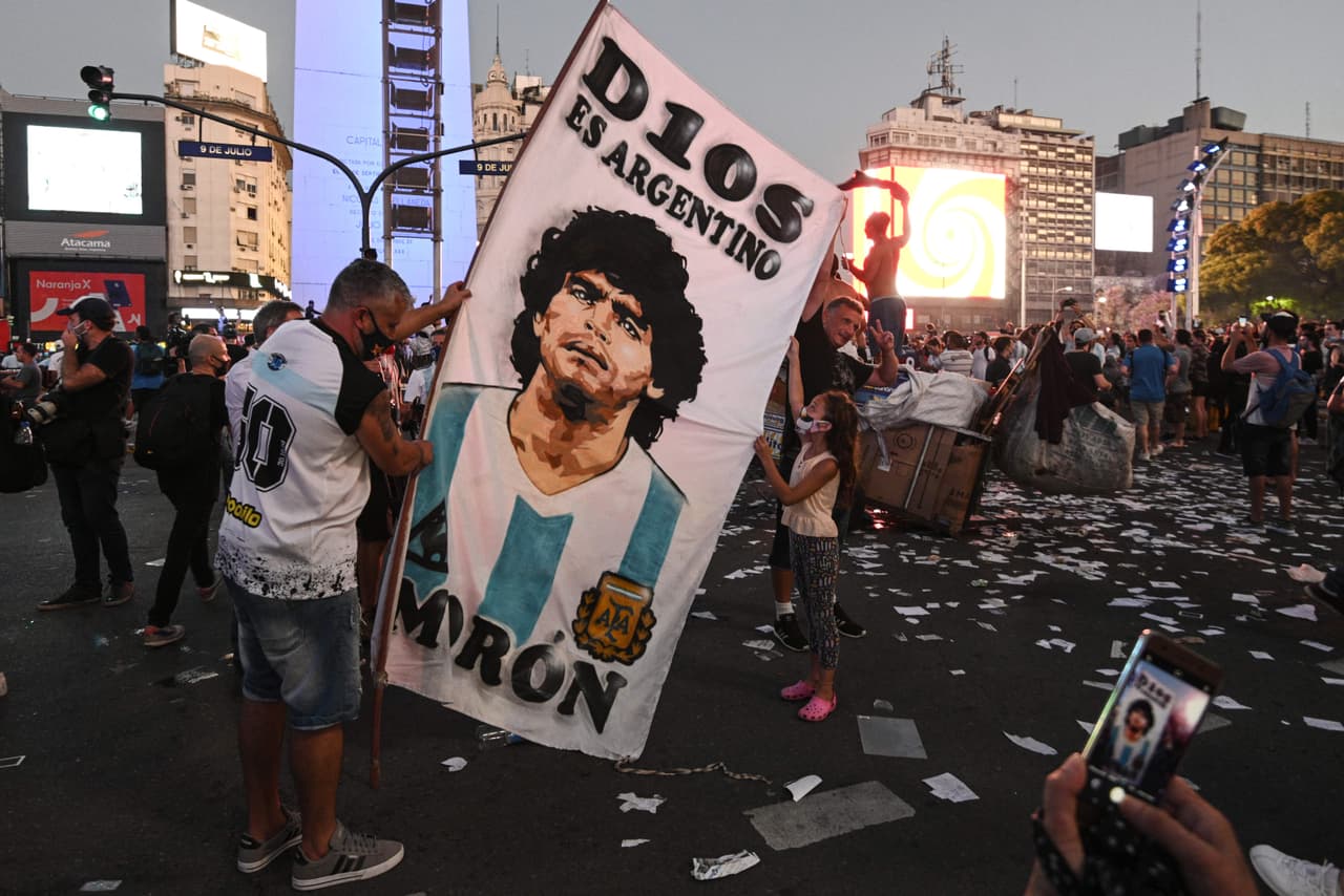 "D10S es argentino", lee una pancarta que sostiene un hombre que viste una camiseta con el 10 en la espalda, dorsal con el que se identifica a Maradona.
<br>