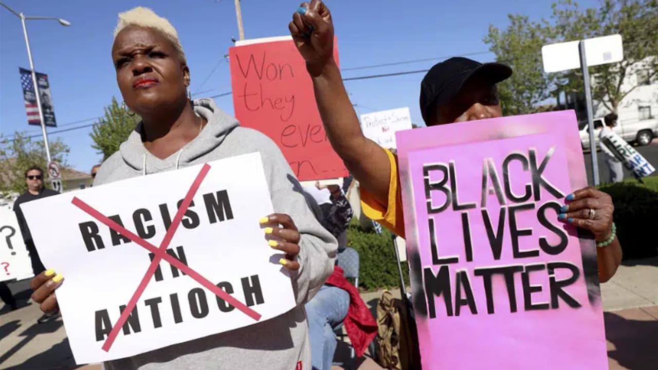 Kiora Hansen y Della Currie, de izquierda a derecha, protestan durante una manifestación en la sede de la policía de Antioch en Antioch, California, el martes 18 de abril de 2023.