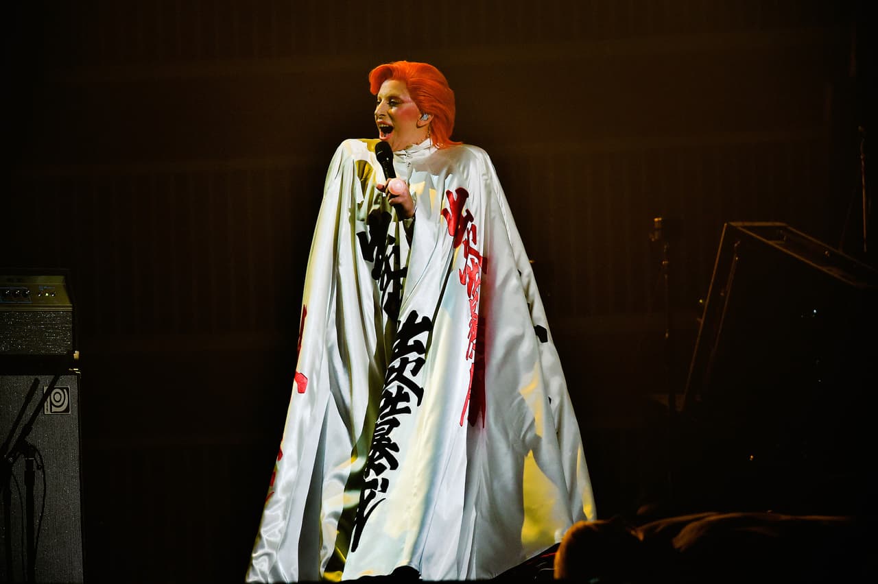 Hasta que apareció en escena con uina capa multicolor, el cabello naranja como Bowie lo usaba y con el maquillaje que lo caracterizó.