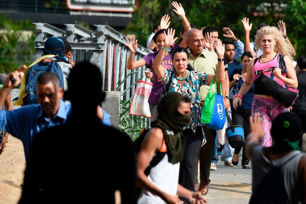 Transeúntes piden a los manifestantes que detengan sus acciones momentáneamente para poder cruzar la calle.
