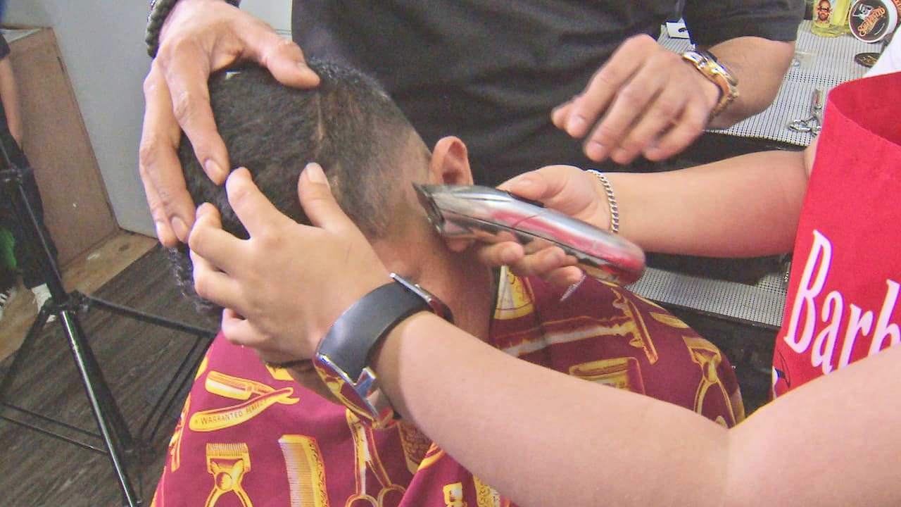 Aunque aún necesita un pequeño taburete para poder atender a sus clientes, Alijah demuestra las habilidades que posee para cortar el cabello y manejar todas las herramientas de peluquería.