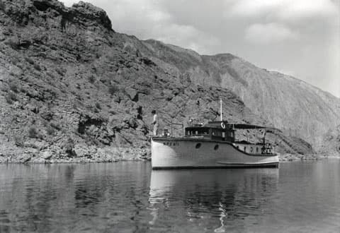 Unos hombres pescan bagres desde un bote del Servicio de parques en el Área Recreacional Nacional Boulder Dam (ahora conocida como Área Recreativa Lago Mead). El año es 1939.