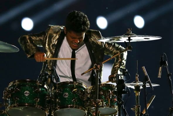 Un cuidado estilismo retro, una banda llena de energía y una particular mezcla de soul y rock sirvieron al cantante Bruno Mars para cautivar a la millonaria audiencia del Super Bowl durante el descanso de la gran cita anual del fútbol americano. Mars, de sólo 28 años y sobre quien planeaba la duda de si sería capaz de enfrentarse a un escenario de tal calibre, optó por un show directo y contundente. Tras una breve introducción a cargo de un coro de niños, un espectacular solo de batería sirvió para abrir el fuego y dar paso rápidamente al gran éxito "Locked Out of Heaven". Impecablemente vestido con una chaqueta dorada, despachó el tema junto a una banda con una amplia sección de viento que se lució en las coreografías. Sin más dilación, Mars descargó su segundo hit, "Treasure", y a continuación demostró su capacidad para fusionar el soul, el pop y el rock integrando en su espectáculo a los Red Hot Chili Peppers. La banda de Anthony Kiedis y Flea puso a saltar a todo el estadio Metlife con su clásico "Give it Away". Los rockeros californianos, a pecho descubierto como manda la tradición, solo necesitaron un par de minutos para demostrar que siguen en buena forma y ceder de nuevo el protagonismo a Mars.