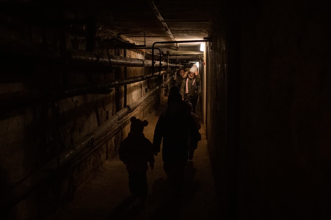 Una familia camina en un sótano usado como refugio antibombas mientras suenan las alarmas en Novoiavorisk, al oeste de Ucrania, este domingo 13 de marzo de 2022. Misiles rusos alcanzaron una base de entrenamiento militar cerca de la frontera oeste de Ucrania con Polonia, miembro de la OTAN, matando a 35 personas, luego de las 
<a href="https://www.univision.com/noticias/mundo/guerra-rusia-ucrania-ultimas-noticias-ucrania-y-rusia-retomara-el-dialogo-este-lunes" target="_blank">amenazas rusas</a> de que atacaría a convoys de envíos de armas que ayuden a combatientes ucranianos.