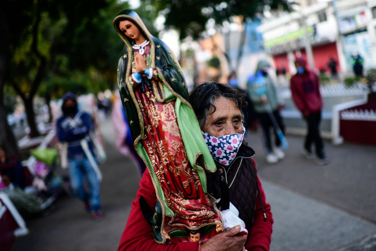 Una mujer lleva una imagen de la virgen de Guadalupe en la explanada de la Basílica, en la capital mexicana.
