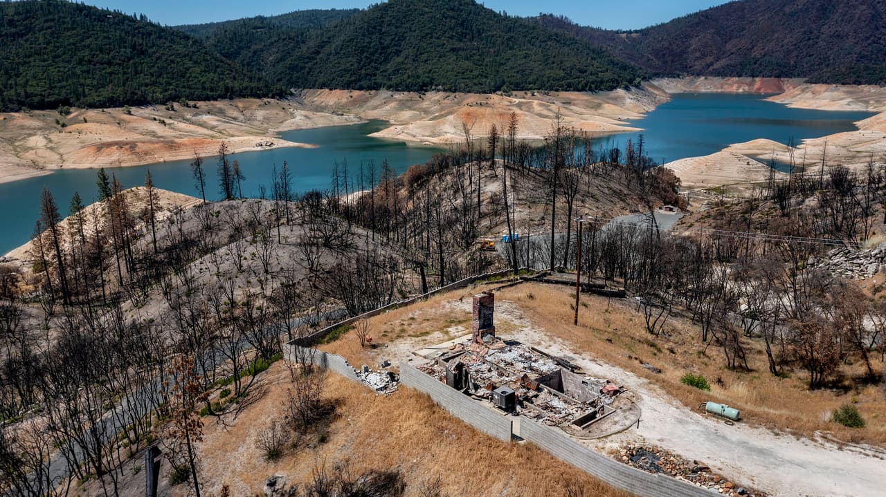 Una casa destruida en el incendio del North Complex de 2020 junto al lago Oroville, en California. Cuando se tomó esta fotografía, el 23 de mayo, este embalse estaba al 39% de su capacidad. 
<br>
<br>Los funcionarios del estado temen que la sequía provoque que este lago, uno de los embalses más importantes del estado, alcance su mínimo histórico en agosto. Esto podría provocar el cierre de la mayoría de las rampas para botes y la parada de una planta hidroeléctrica en el momento de mayor de demanda de energía en el estado.
<br>