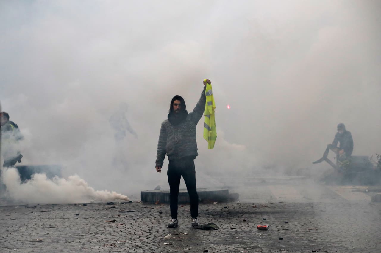 Un manifestante muestra su chaleco amarillo durante las protesta contra las políticas del gobierno actual. La policía francesa disparó gases lacrimógenos y cañones de agua para dispersar a los manifestantes. La calma regresó al centro de la capital a primera hora de la noche. Numerosas acciones pacíficas, como manifestaciones, bloqueos en carreteras y en zonas comerciales, se llevaron a cabo en casi toda Francia, en el marco de esta segunda jornada de movilización, una semana después del comienzo de este movimiento. AP/Christophe Ena.