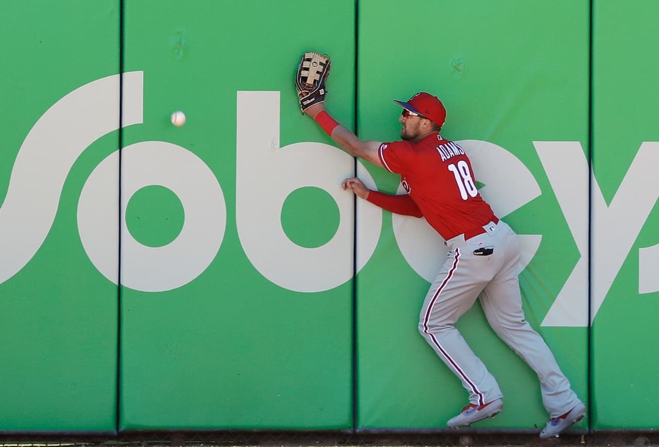 Lane Admas de los Philadelphia Phillies no le llega a este batazo que se estrelló contra la barda en el duelo de esta tarde ante los Toronto Blue Jays.