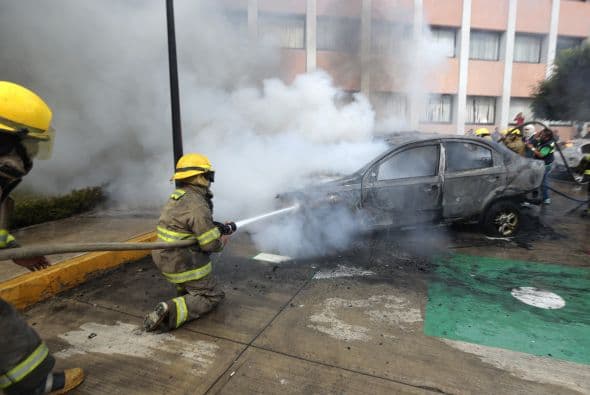 Bomberos tratan de extinguir el fuego en los vehículos incendiados durante las protestas en el estado de Guerrero. Los manifestantes exigen la presentación con vida de los 43 estudiantes de Ayotzinapa.
