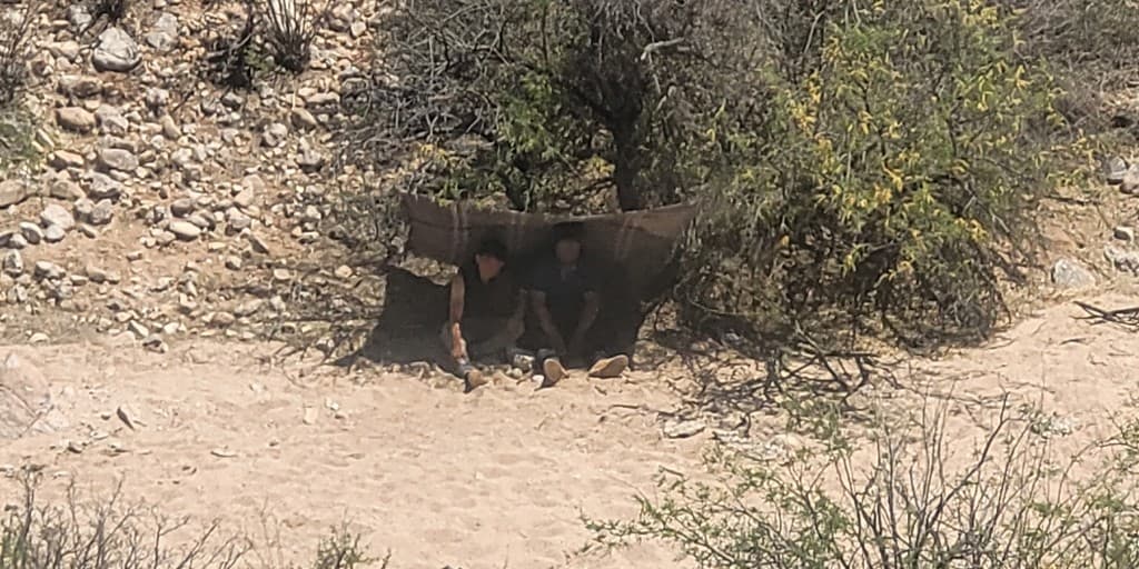 Desde el aire los observaron cuando intentaban cubrirse con una manta bajo un arbusto. Los dos inmigrantes llamaron al 911.