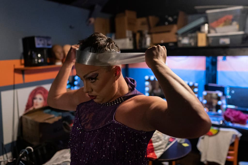 La drag queen Harpy Daniels se envuelve la cabeza con cinta adhesiva para ponerse pasadores para asegurar una peluca y actuar en el evento Rainbow Special Interest Group of NAFSA. 
<br>