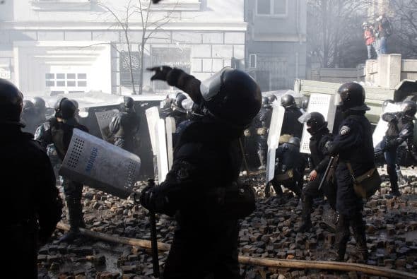 La policía ucraniana cercó hoy a los manifestantes en el corazón de las protestas opositoras de la plaza de la Independencia de Kiev (Maidán), tras una jornada en la que murieron 14 personas en los disturbios que estallaron en la capital. Víktor "Yanukóvich se ha convertido en un presidente sangriento", aseguró hoy el dirigente opositor Vitali Klitschkó en un llamamiento a los países democráticos para que intervengan en Ucrania y frenen la violenta confrontación. Según se acercaba la medianoche, los temidos Berkut, el destacamento antidisturbios, estrechaban el cerco en torno a los miles de manifestantes concentrados en el Euromaidán, bastión de las protestas desde el pasado 21 de noviembre. "Los extremistas de la oposición han cruzado la línea roja; matan a inocentes en la calles de la capital de Ucrania, vejan a mujeres, queman edificios y automóviles. Y si los disturbios continúan, nos veremos obligados a actuar con firmeza", rezaba el ultimátum del Servicio de Seguridad y el Ministerio del Interior de Ucrania. Advierten a los americanos que se queden dentro de las casas y de nuevo se sienten explosiones en la ciudad.