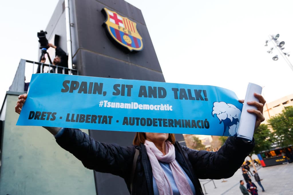 La gente acude al Camp Nou con las cartulinas de 'Spain, sit and talk' y banderas esteladas, de forma pacífica.