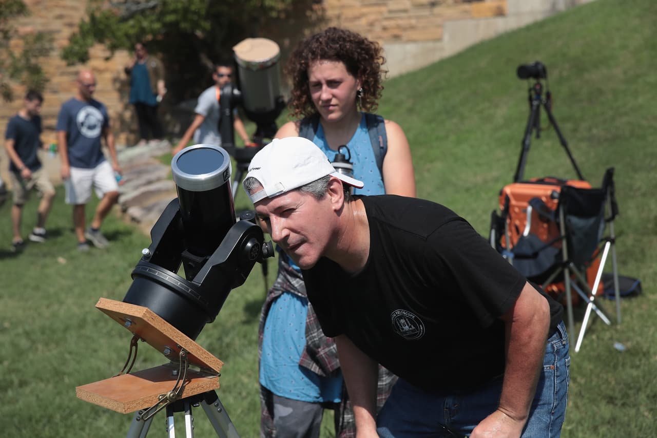<b>El telescopio</b>: El Carbondale, Illinois, una pareja ajusta su telescopio antes de que inicie el eclipse solar total desde el campus de la Universidad del Sur. Illinois disfrutó el fenómeno durante dos minutos y 40 segundos, siendo este el mayor tiempo de exposición. Scott Olson/Getty Images