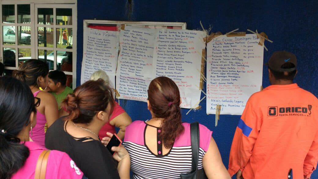 Familiares revisando una lista de lesionados en instalaciones del IMSS.