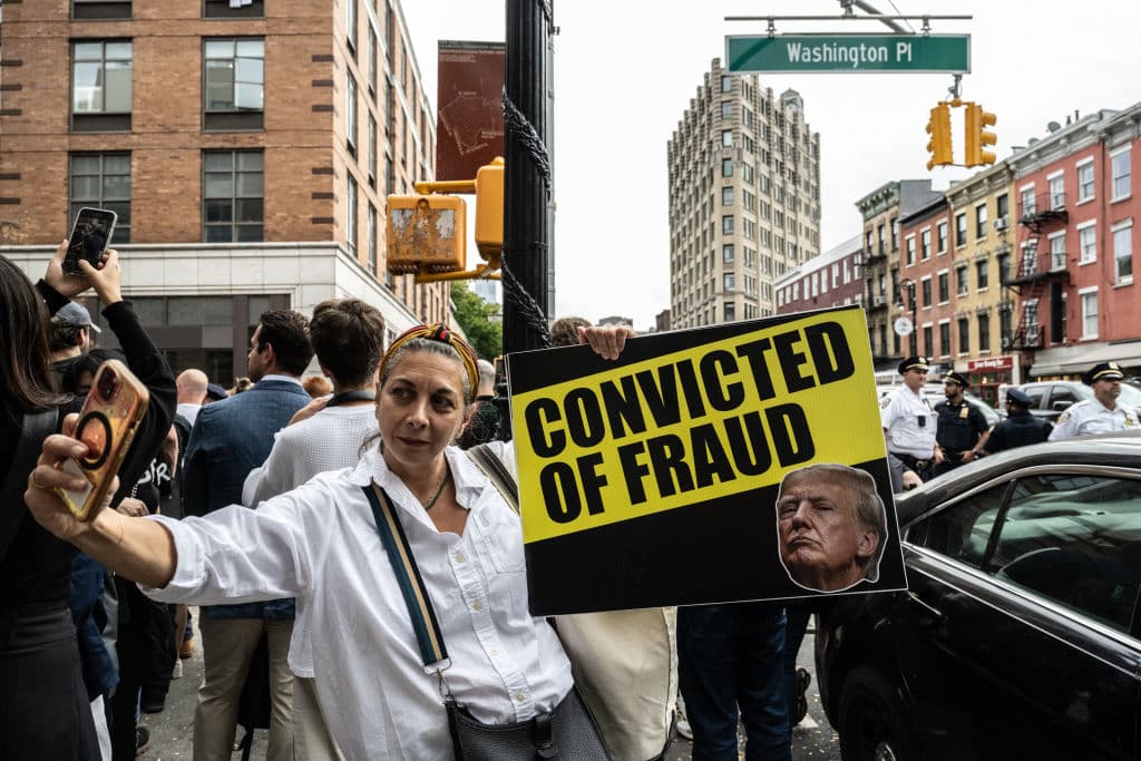Activistas anti-Trump se reúnen cerca de Washington Square Park con carteles críticos.