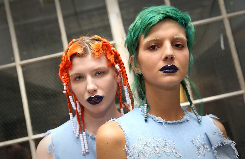 Melenas de colores llamativos como el naranja y el verde perico complementaron el look de las modelos que desfilaron para 
<a href="http://fyodorgolan.co.uk/">Fyodor Golan</a>. Vemos (de nuevo) el deseo por borrar las cejas. Mientras que en los labios de color morado obscuro se marca con ayuda de un delineador blanco líquido la zona conocida por los maquillista como el arco de cupido. Este tono blanco da el efecto de unos labios más voluminosos.
<br>