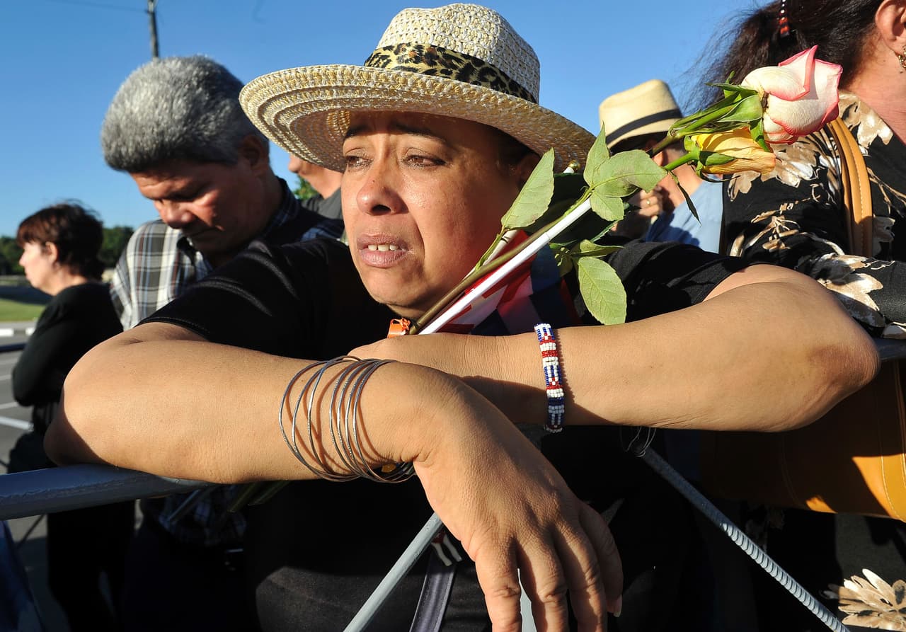 Una mujer lleva una rosa, mientras hace la fila para rendir homenaje a Fidel Castro.