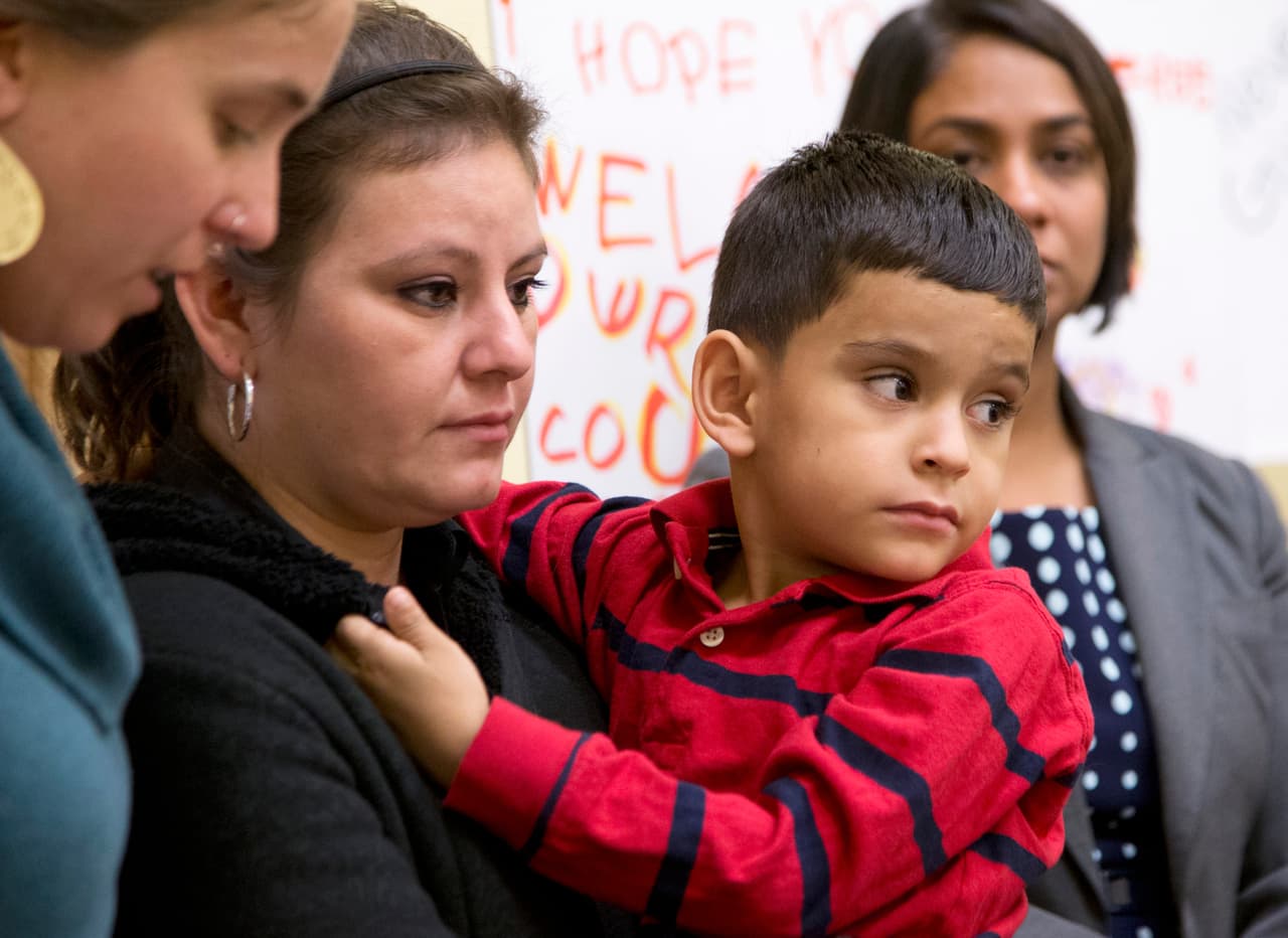 Una mujer centroamericana y su hijo en la conferencia de prensa.