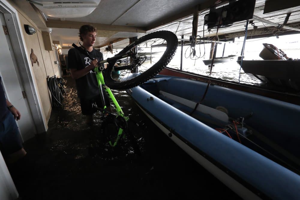 Rudy Horvath Jr. mueve su bicicleta de su casa en West End de Nueva Orleans. El aumento de los niveles en el lago Pontchartrain causó una inundación de unos 2 pies (61 centímetros) en el primer piso de la residencia de los Horvath, la cual está sostenida por pilotes sobre el agua.
