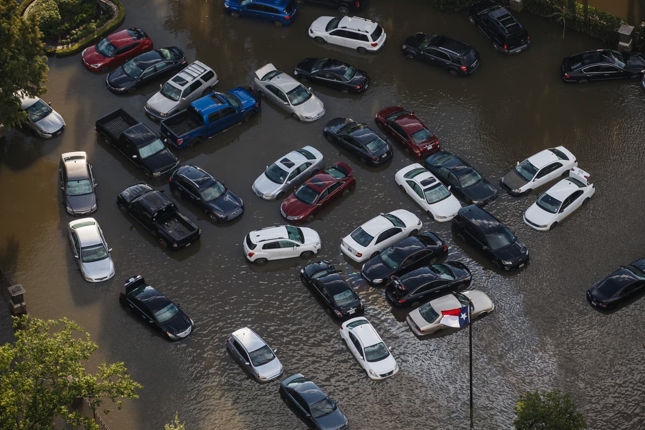 La corriente de la inundación junta a varios vehículos arrastrados por las aguas.