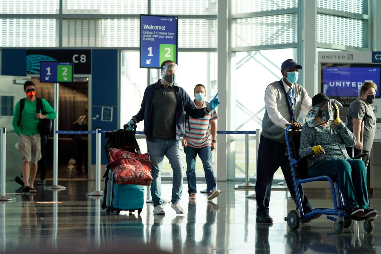Pasajeros con mascarillas llegando etse domingo al aeropuerto intercontinental George Bush en Houston. A pesar del levantamiento de las restricciones todavía se vio poca gente viajando en avión este fin de semana festivo por el Día de los Caídos.