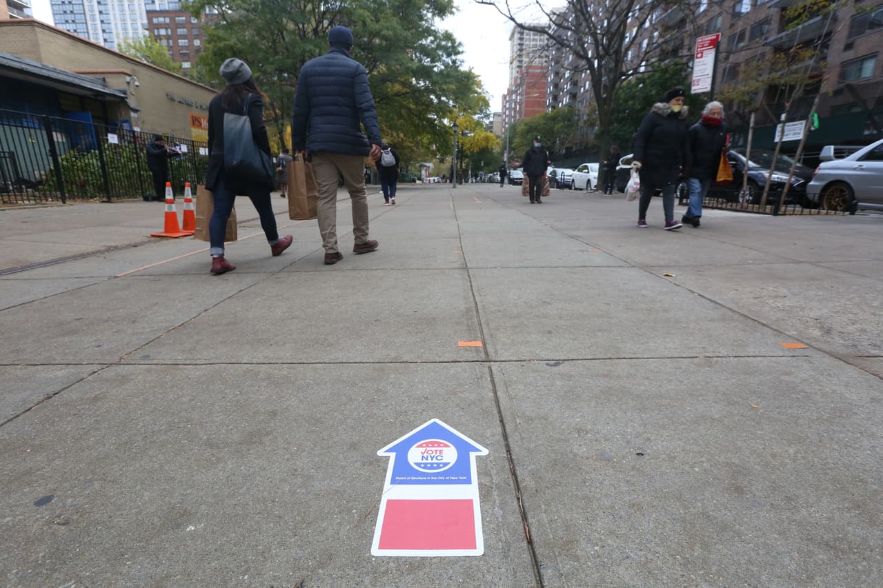 Nueva York vota en la elecciones presidenciales. Etiquetas en el piso demarcan la dirección de la entrada de los centros de votación.