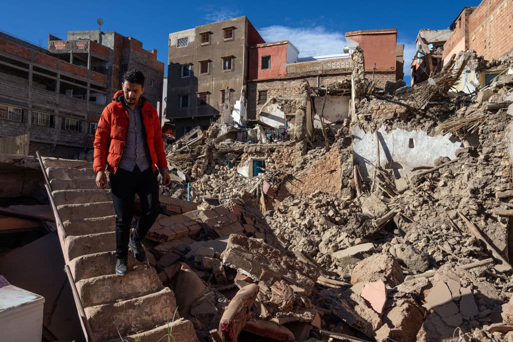 Abdelhamid Aouzal mira desde una escalera que queda en pie los restos de lo que era su casa familiar en Moulay Brahim.