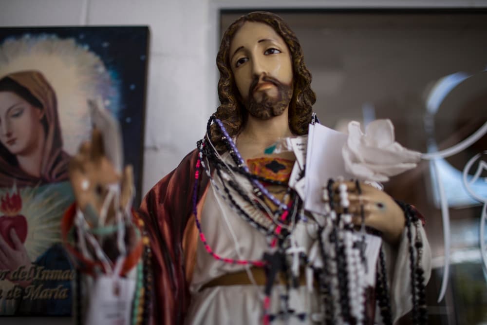 Esta estatua de Jesucristo sostiene documentos de ICE que indentificaron a inmigrantes indocumentados en centros de detención en Estados Unidos. Algunos deportados pasan por la Casa del Migrante en sus primeras horas en México.