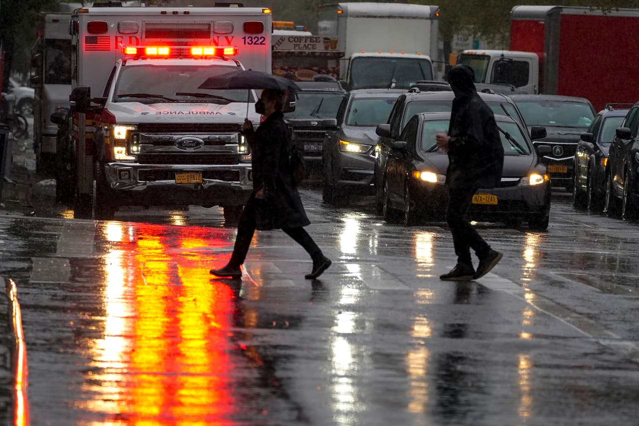 Peatones cruzando bajo la fuerte lluvia la calle Delancey, en Nueva York.